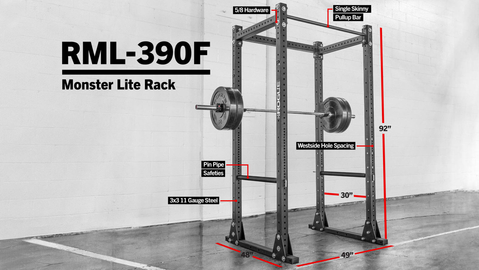 A Rogue flat foot power rack with a barbell loaded with weight plates on a concrete gym floor.